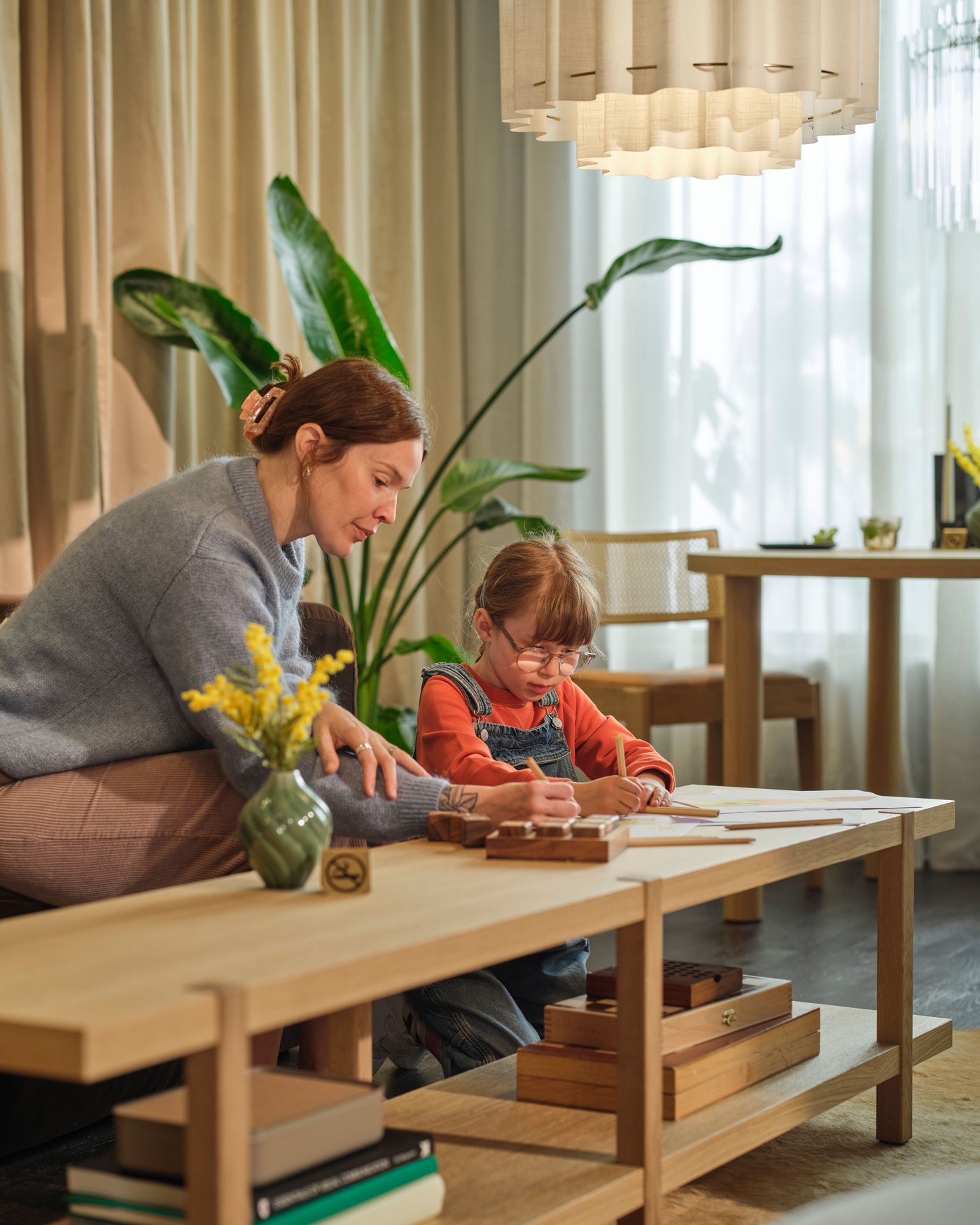 A woman and small child sit coloring at a table in a hotel lobby.