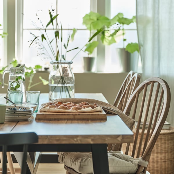 An acacia/black SKOGSTA dining table