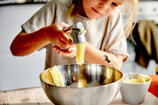 A stainless steel KONCIS garlic press in the kitchen