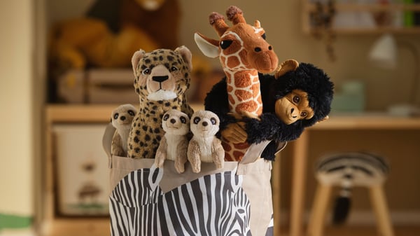 A SANDLÖPARE basket with meerkat/beige SANDLÖPARE savannah soft toys, like a giraffe, monkey and leopard.