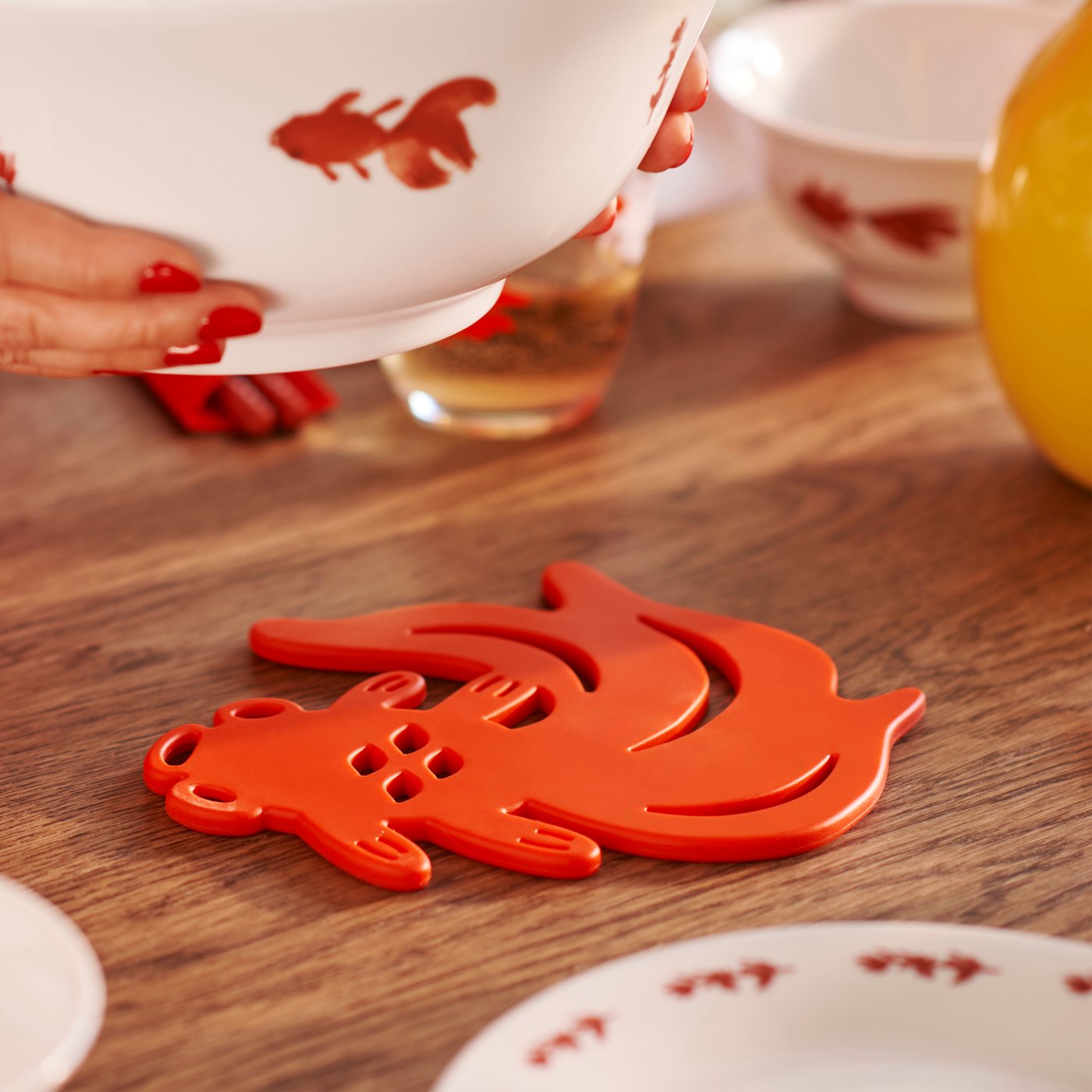 The pot stand's shape is inspired by traditional Chinese art and depicts a playful goldfish – a symbol that is said to represent a wish for wealth and prosperity. Perfect for a New Year party.