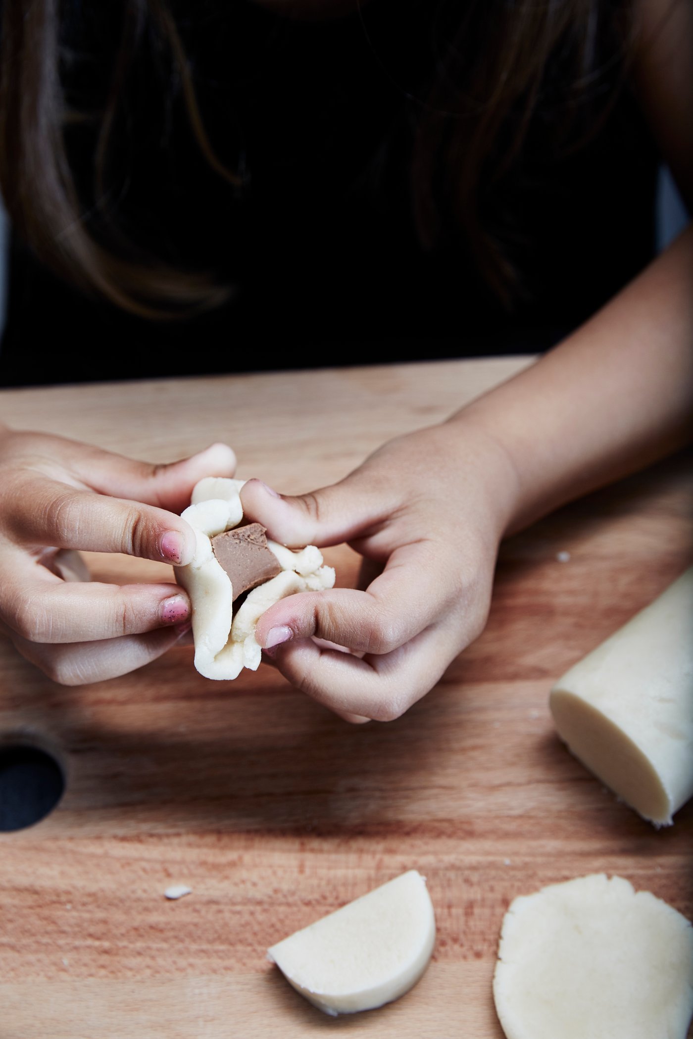 Marzipan wird um ein Stück Schokolade gewickelt.