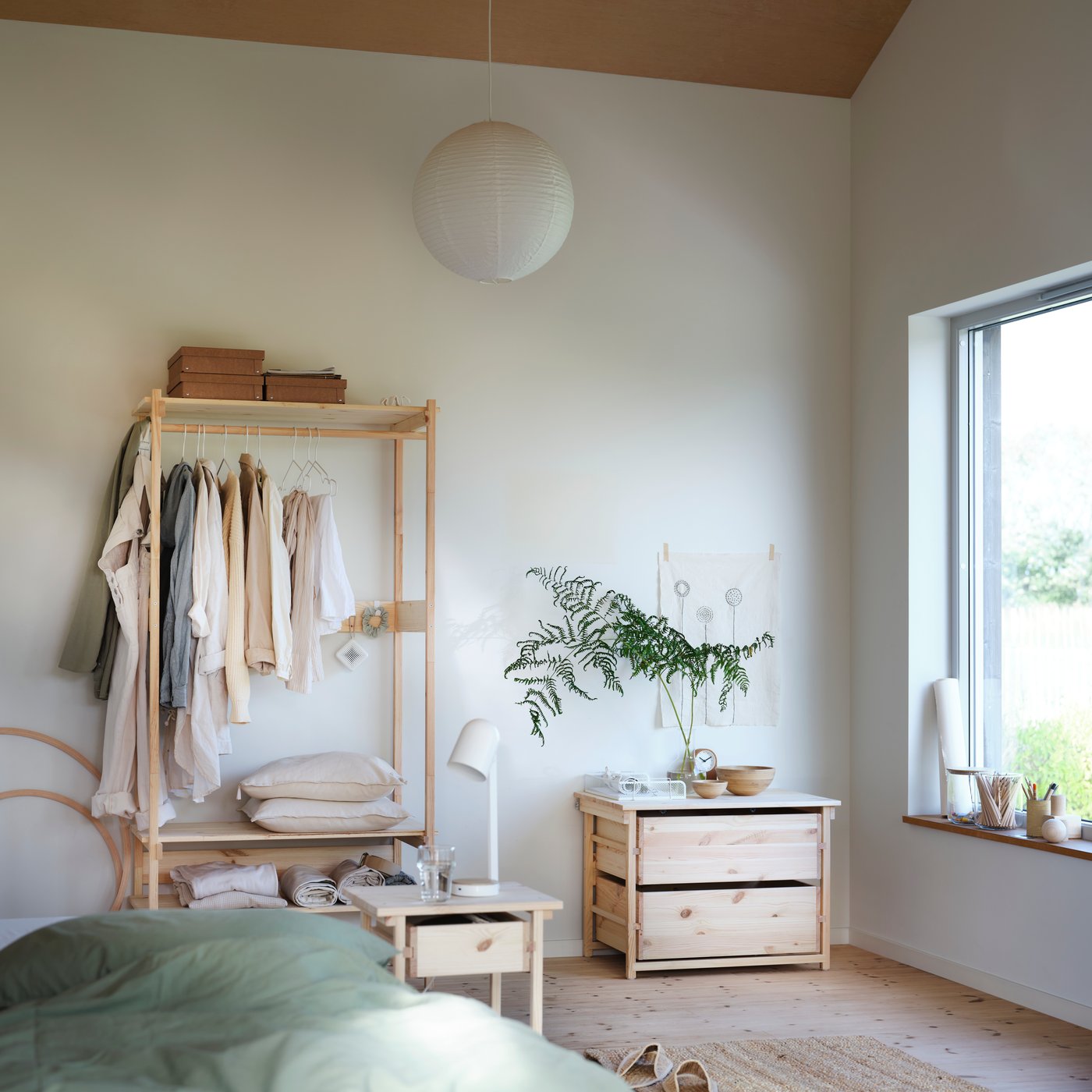 KRONÖREN open wardrobe in pine with rail and shelves placed in a light bedroom with wooden floors and soft textiles.