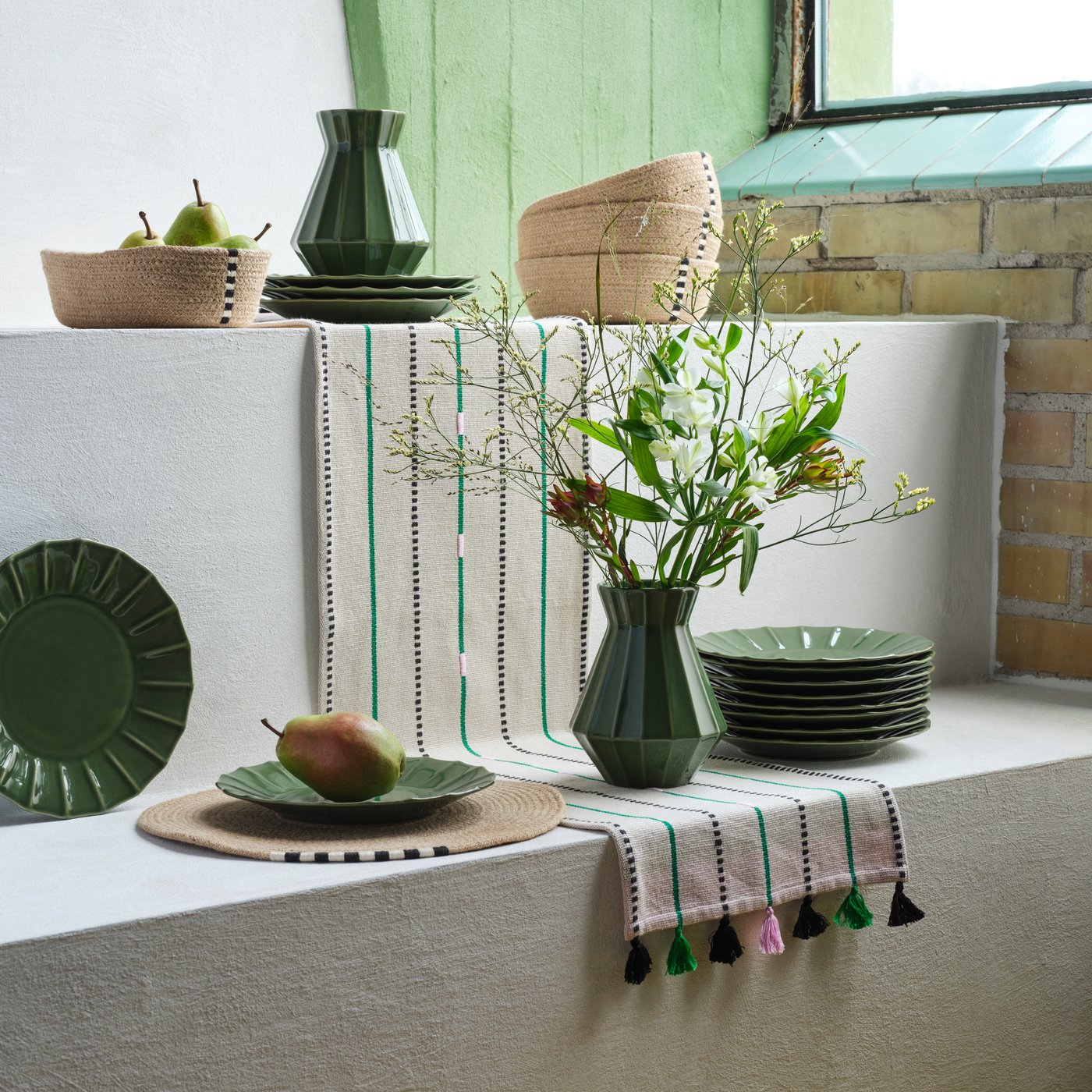 New MÄVINN items, including a green vase, green plates, and a green table runner.