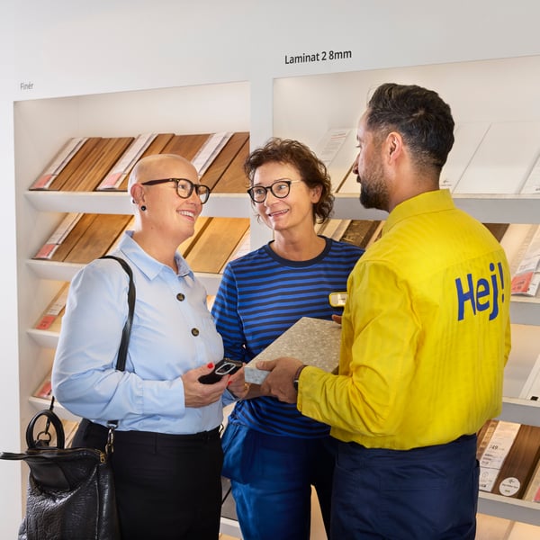 An IKEA employee shows a worktop sample to a customer in an IKEA store.