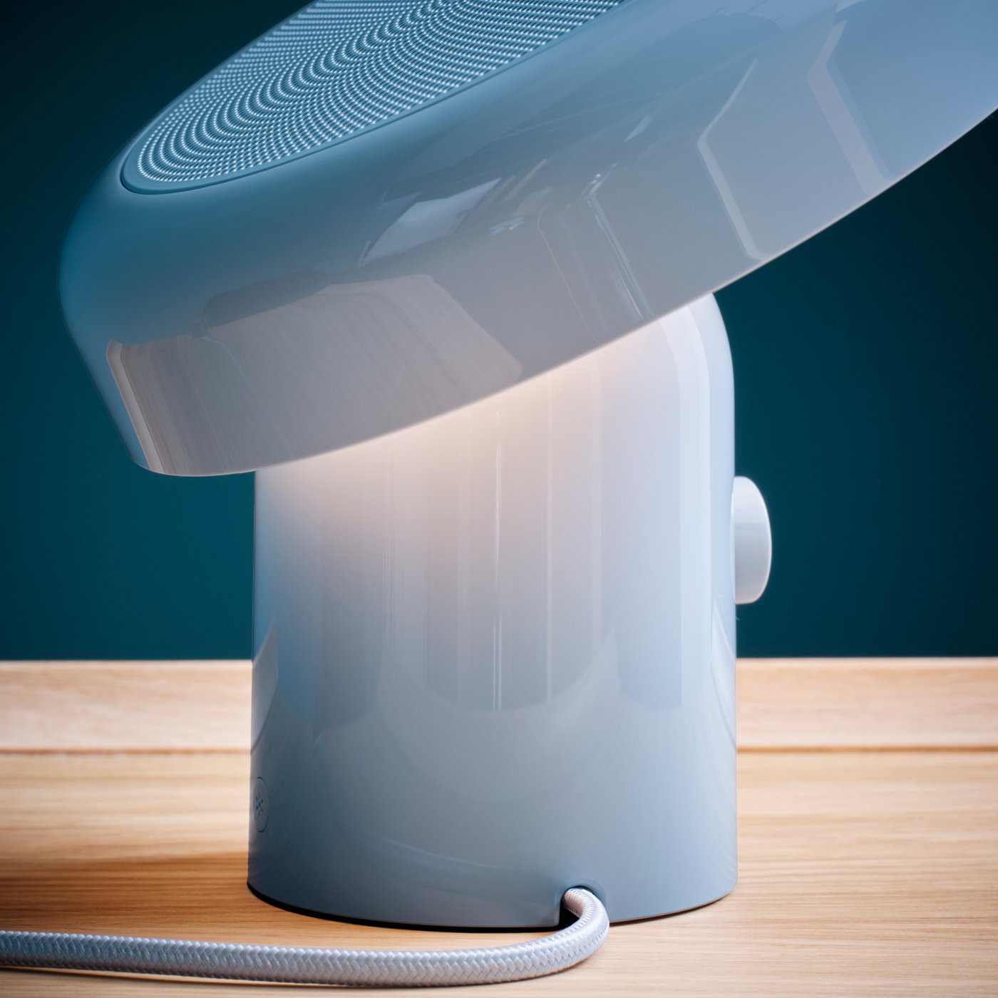 Dettaglio del corpo di una lampada/cassa Bluetooth® di colore azzurro BLOMPRAKT.