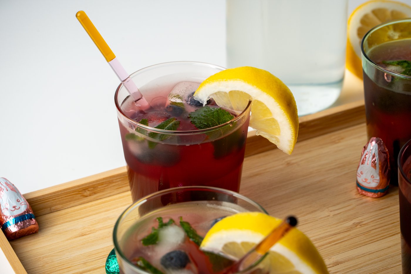 4 Gläser mit Limonaden auf einem Holztablett präsentiert