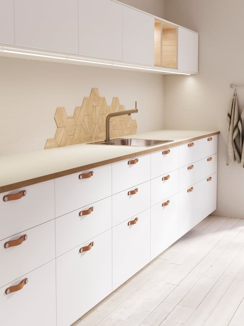 Kitchen with white base cabinets with three drawers, open cabinet, wall cabinet, inset sink, mixer tap, kitchen towels.