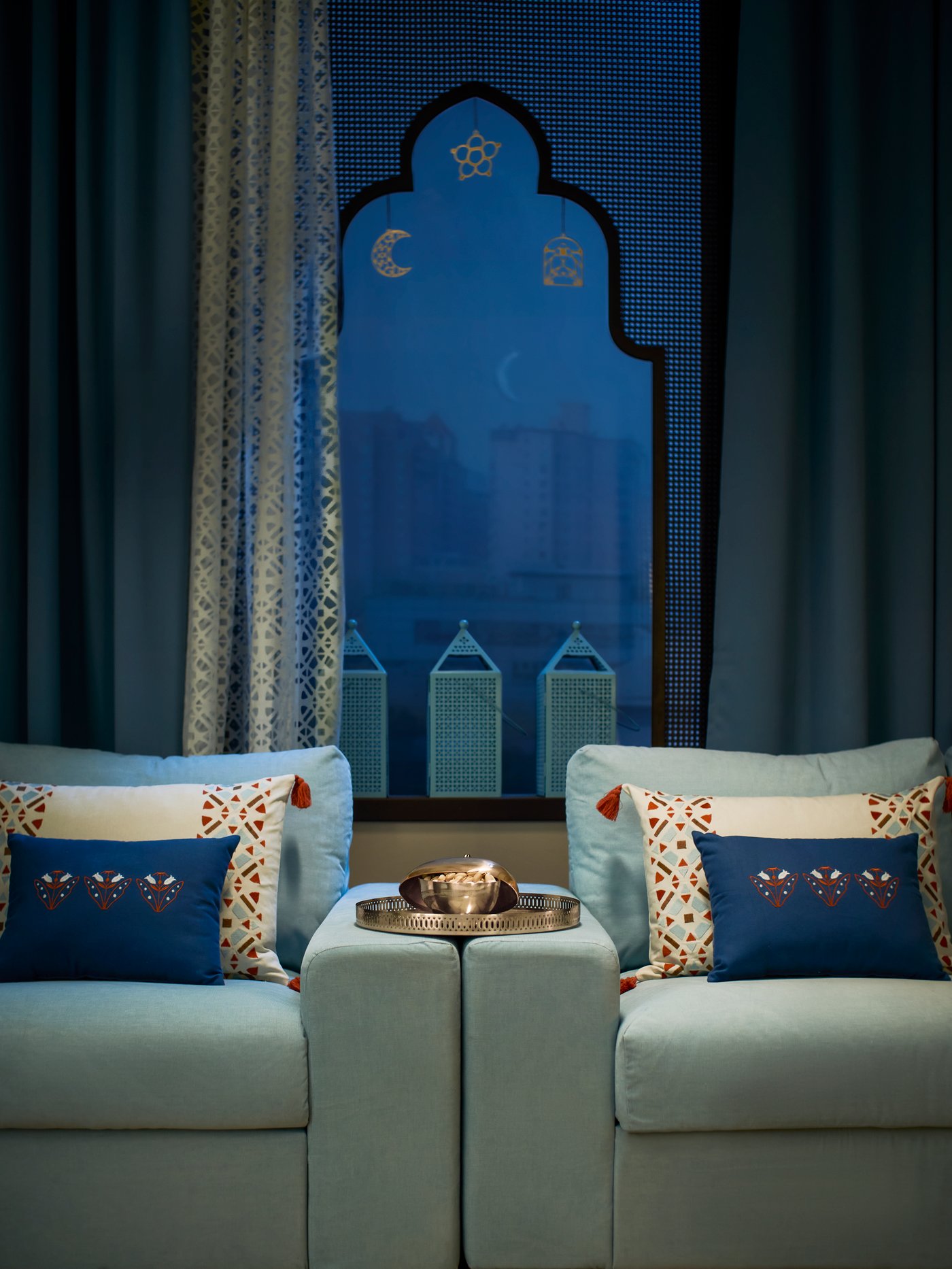 Mangkuk hidangan GOKVÄLLÅ di atas dulang GOKVÄLLÅ, terletak di tempat letak tangan sofa biru bersebelahan yang dihiasi dengan kusyen GOKVÄLLÅ.