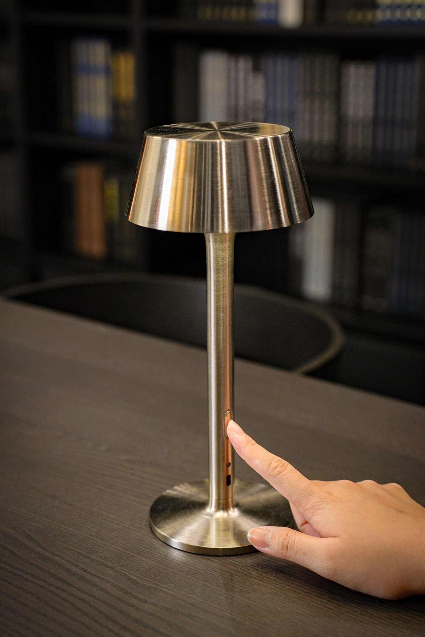 Curious Library room setting at IKEA Tampines, featuring a close-up of battery-operated dimmable/nickel-plated AVHÅLL LED portable lamp.