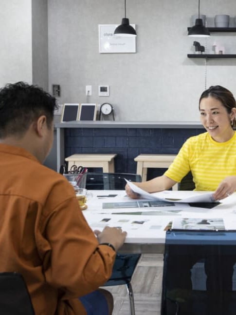 イケアのスタッフがお客さんに机に座って説明している様子