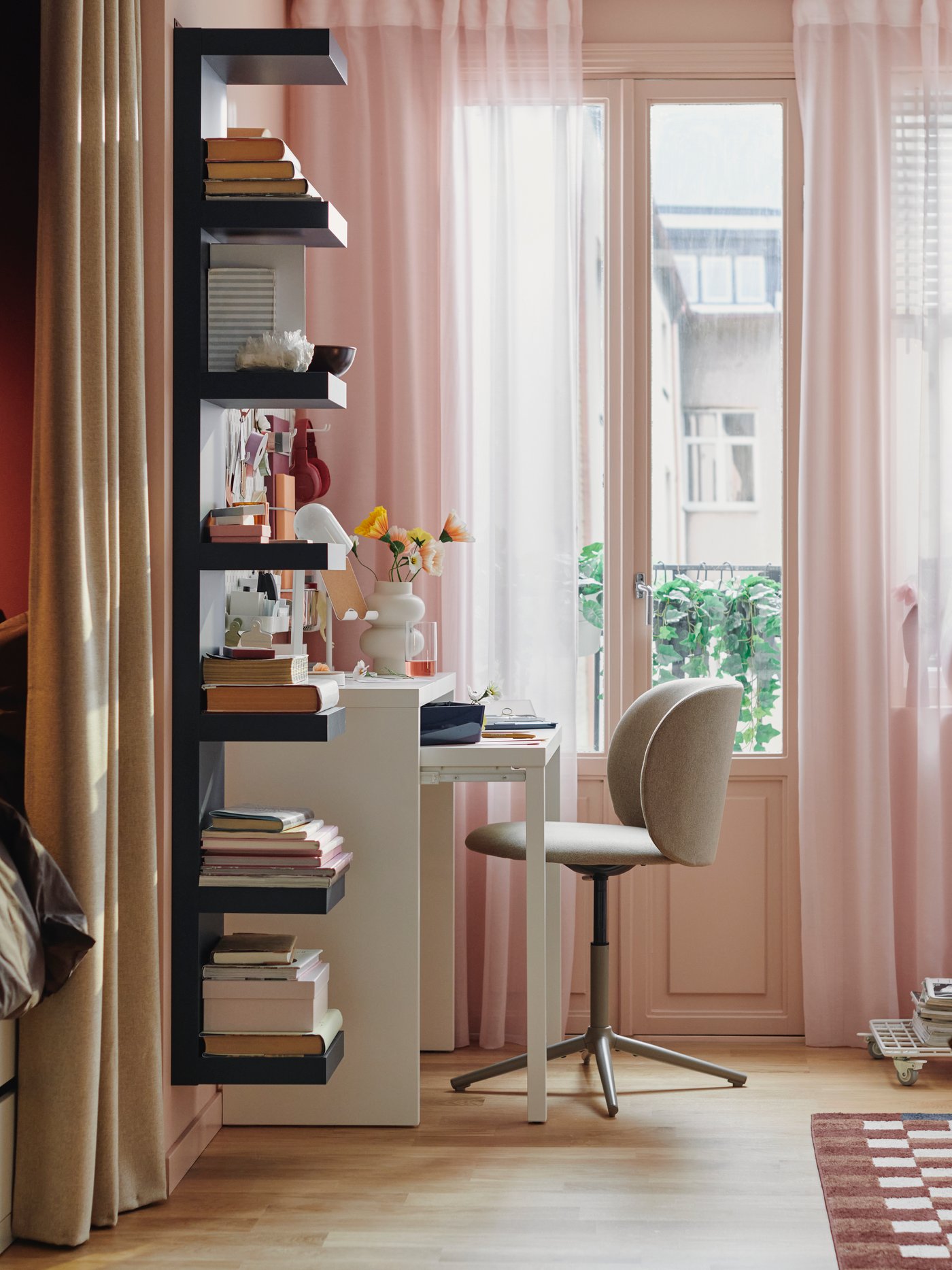 A dark beige KRYLBO swivel chair stands at a white LÄNGDHOPP pull-out desk near a window in a small living area.