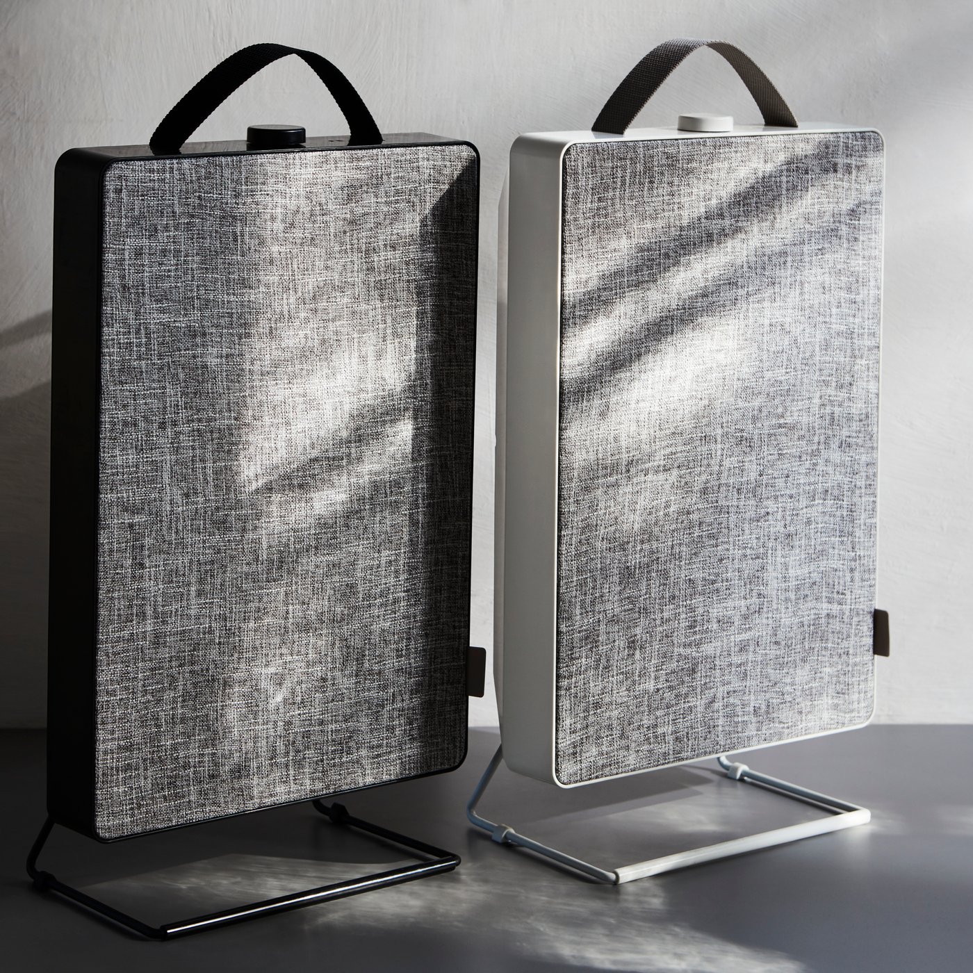 Biały i czarny oczyszczacz powietrza FÖRNUFTIG stojące w szarym pokoju.