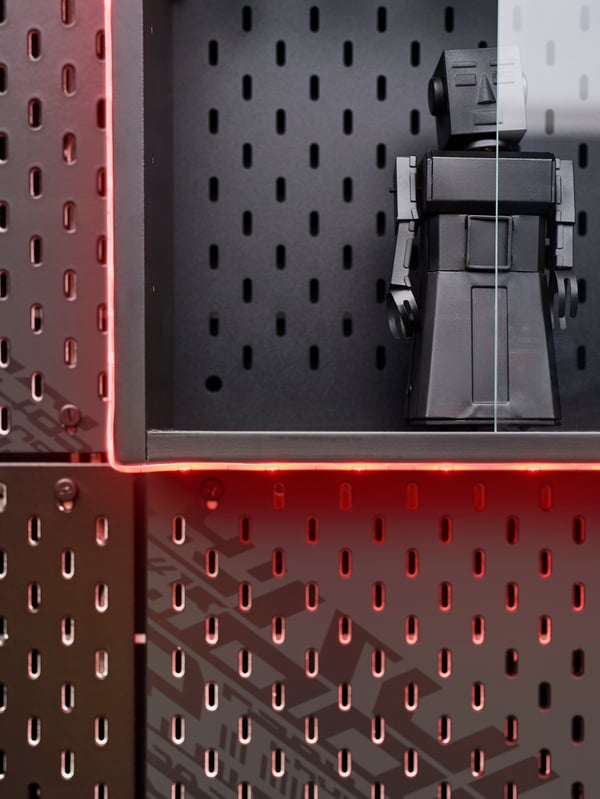 A corner of an UPPSPEL glass-door cabinet and pegboard, displaying a grey robot and framed by a LEDBERG LED light strip.