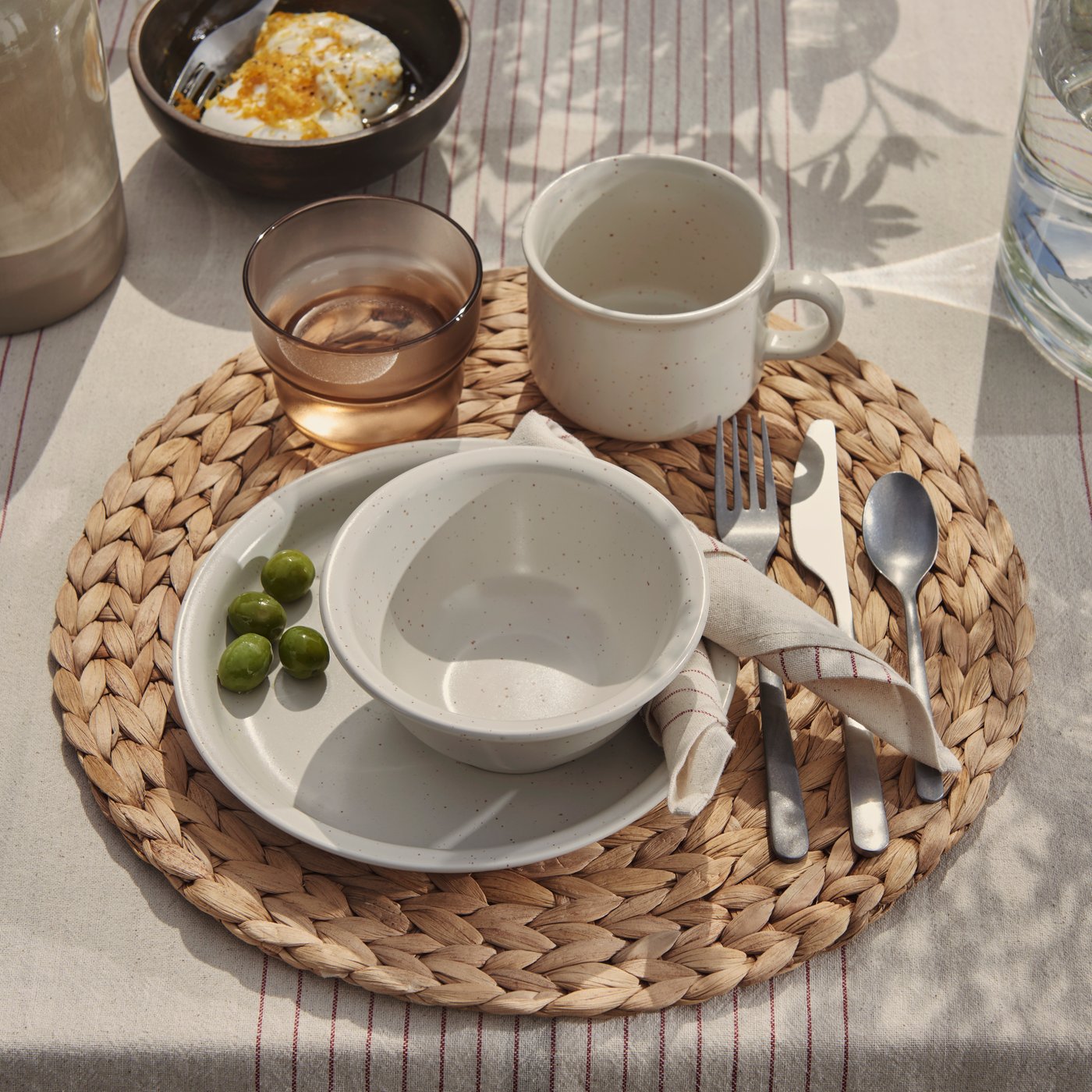 A stripe pattern red/natural VIPPSTARR tablecloth outside