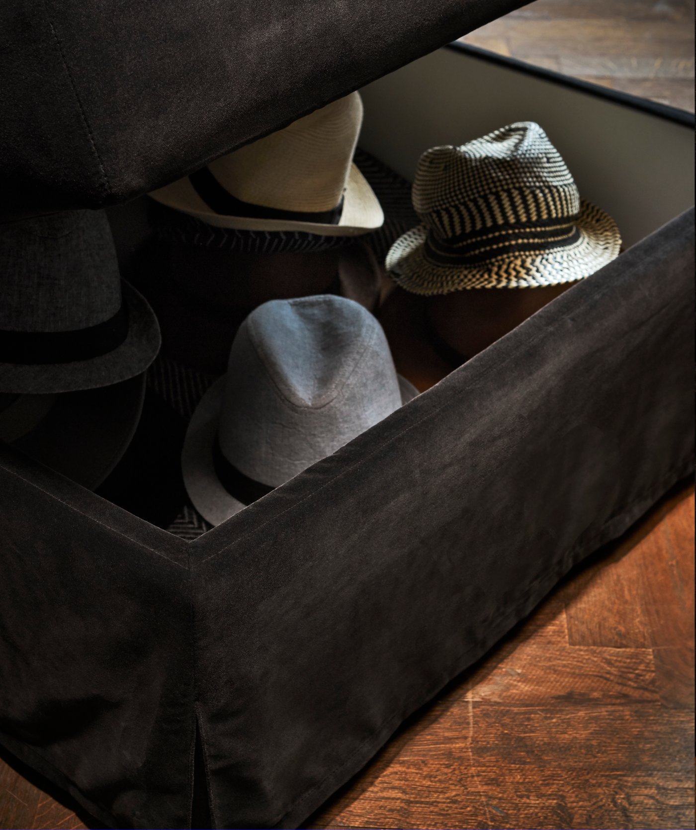 FÄRLÖV Hocker mit Aufbewahrung Djuparp dunkelgrau, in der Aufbewahrung sind Hüte zu sehen.