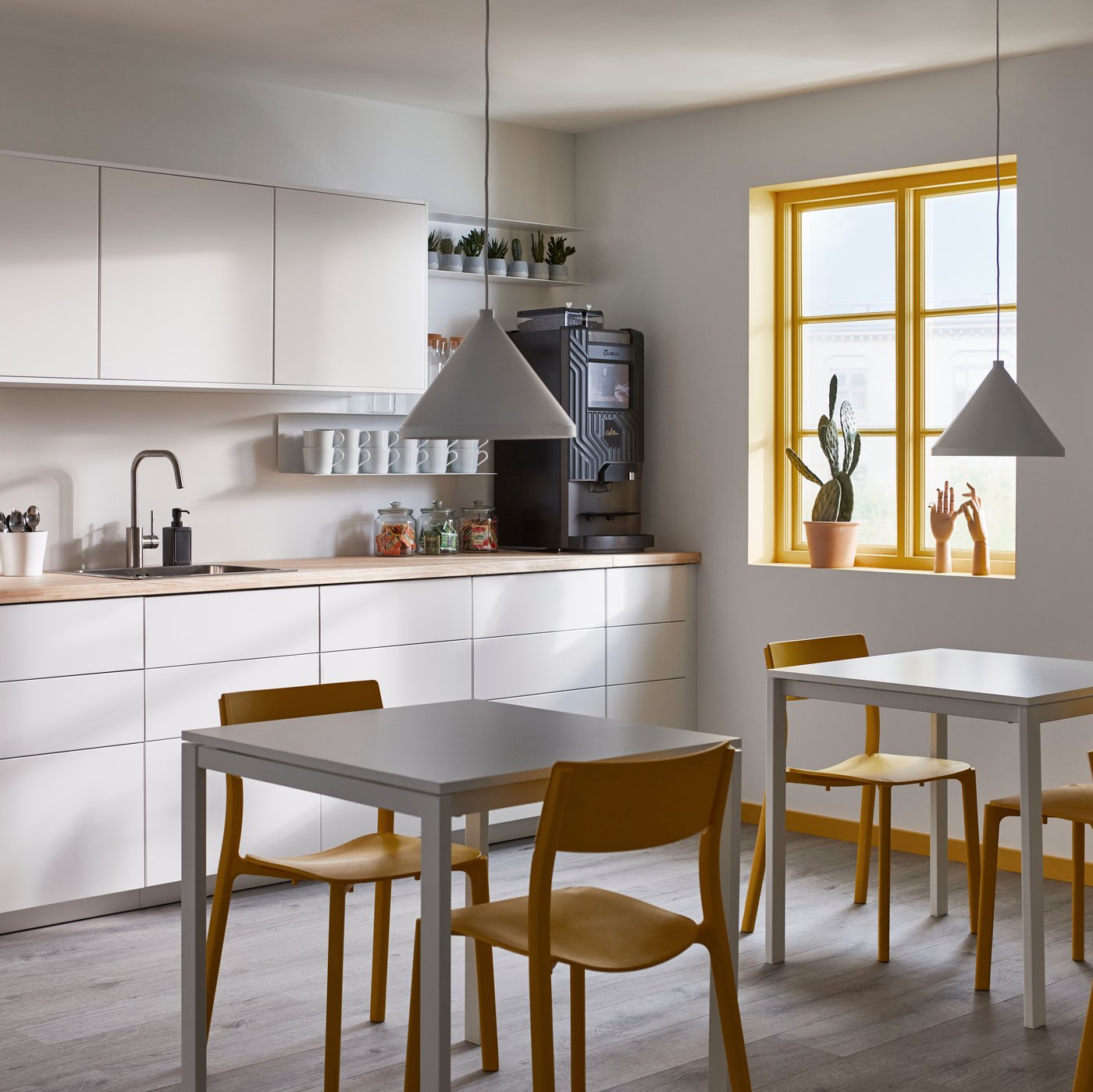 Eine weiße IKEA Küche, die in einem Büro präsentiert wird.