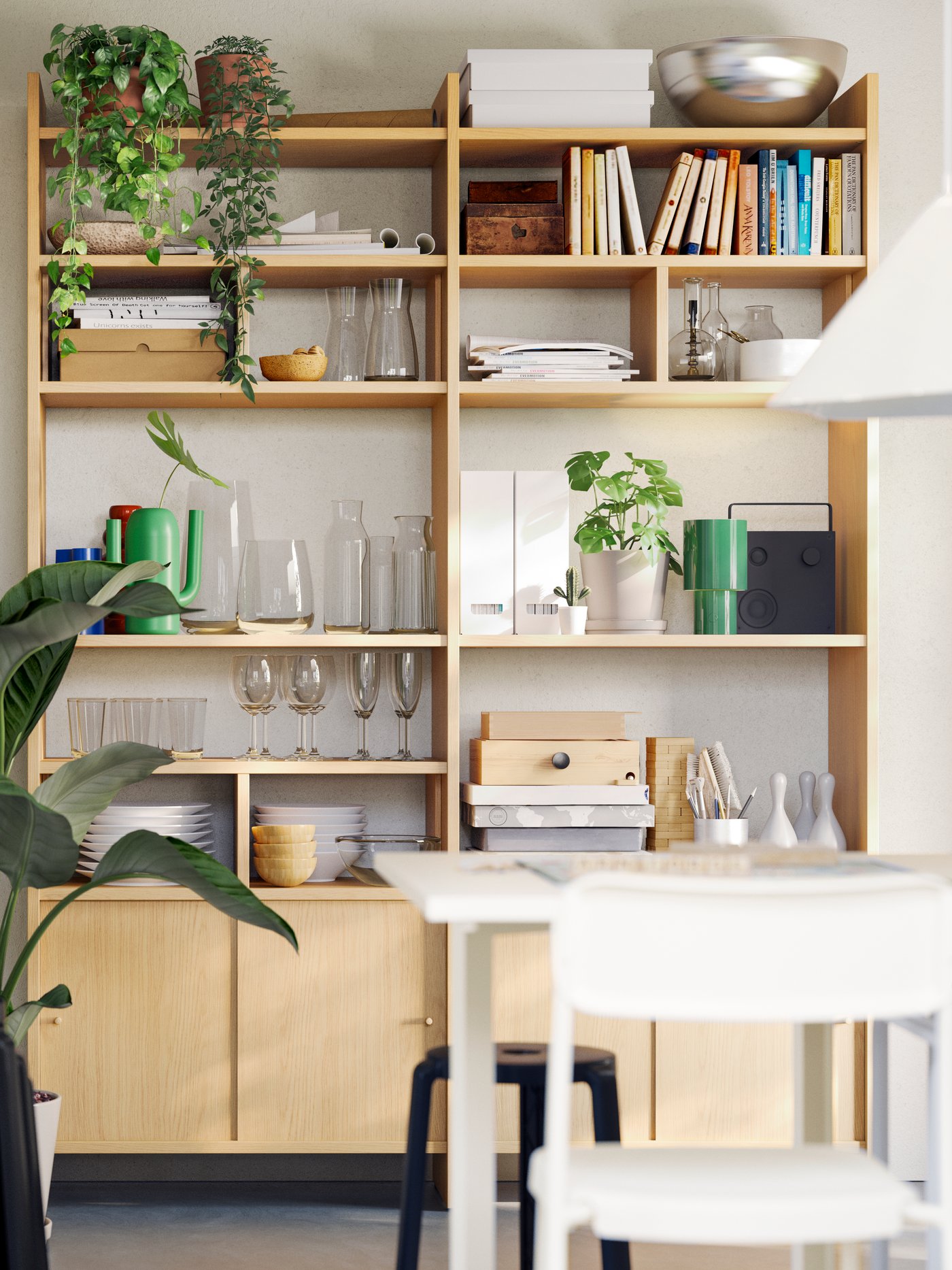 A LÅDMAKARE storage combination with sliding doors stores glasses, pots, and plants in a dining area with a table and chairs.