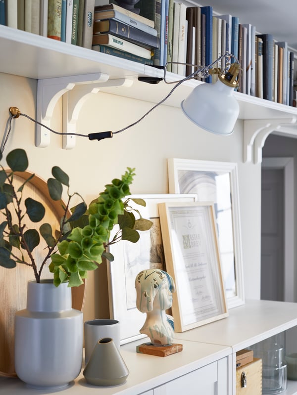 IKEA RAMSHULT white brackets, with BERGSHULT white wall shelves mounted next to each other for an elongated storage solution.
