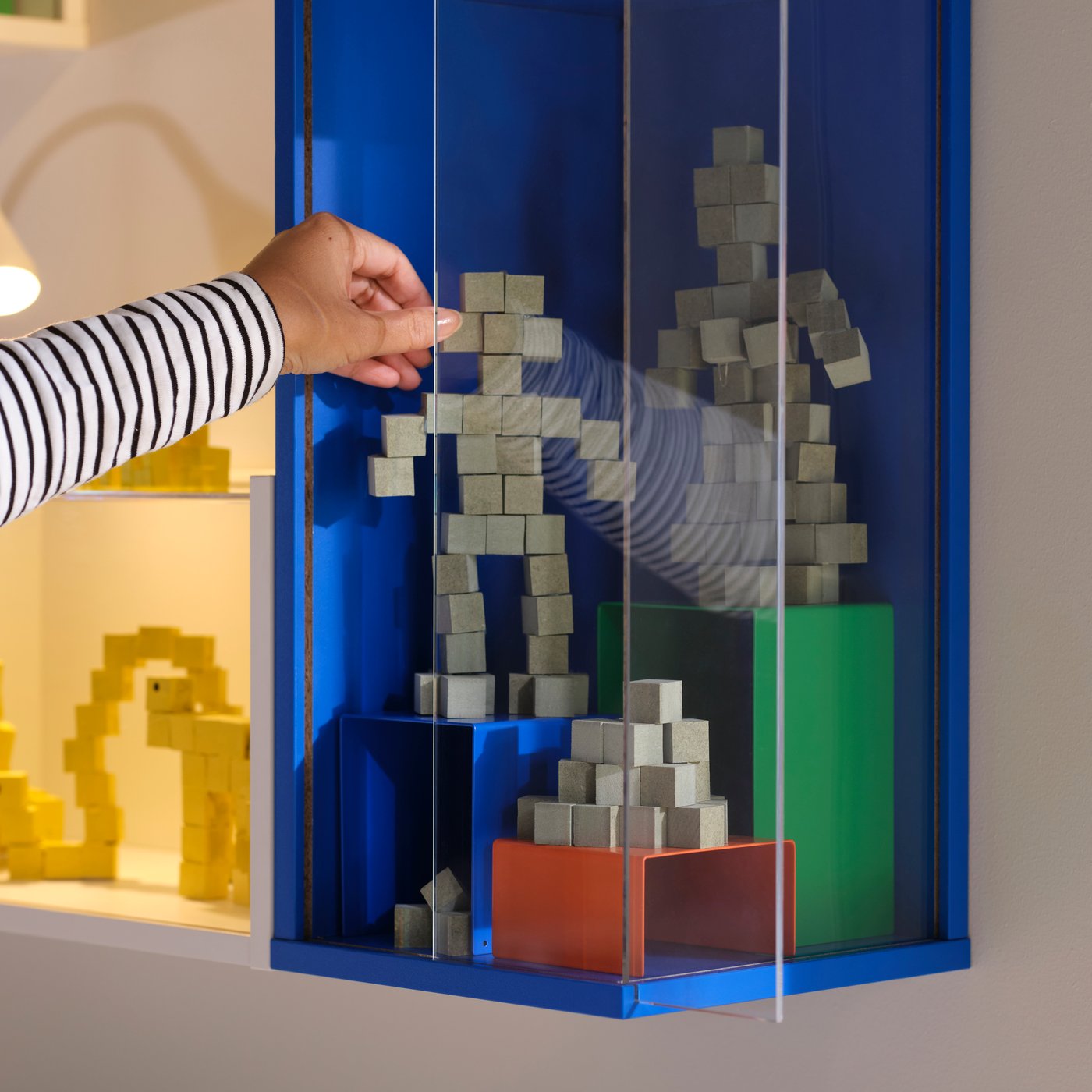 A bright blue BRÄNNBOLL wall-mounted display cabinet