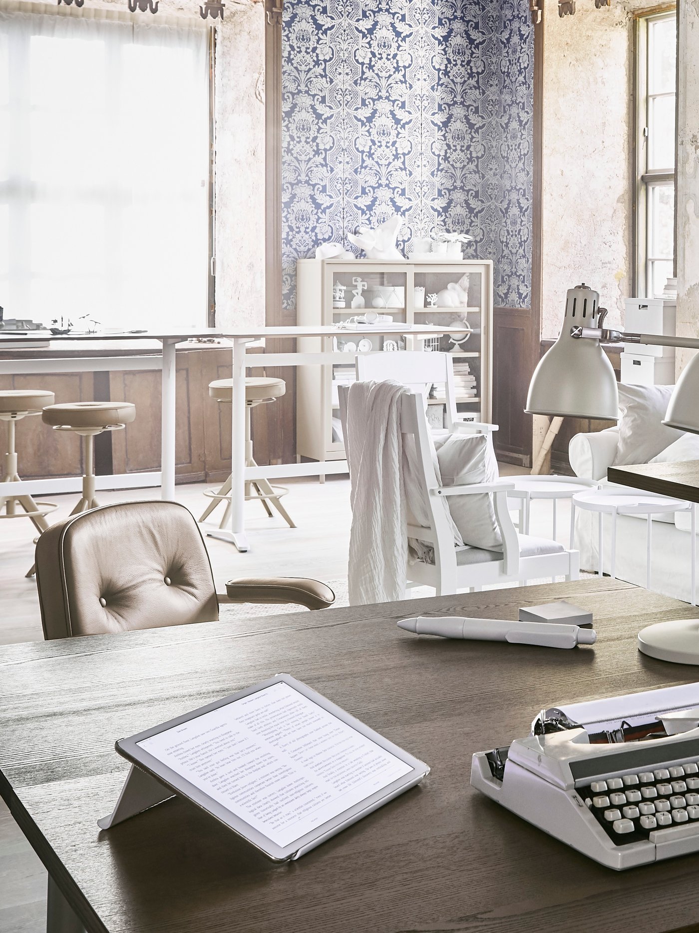 Ein offenes Büro in einem Loft mit hellen Büromöbeln im Industriestil.