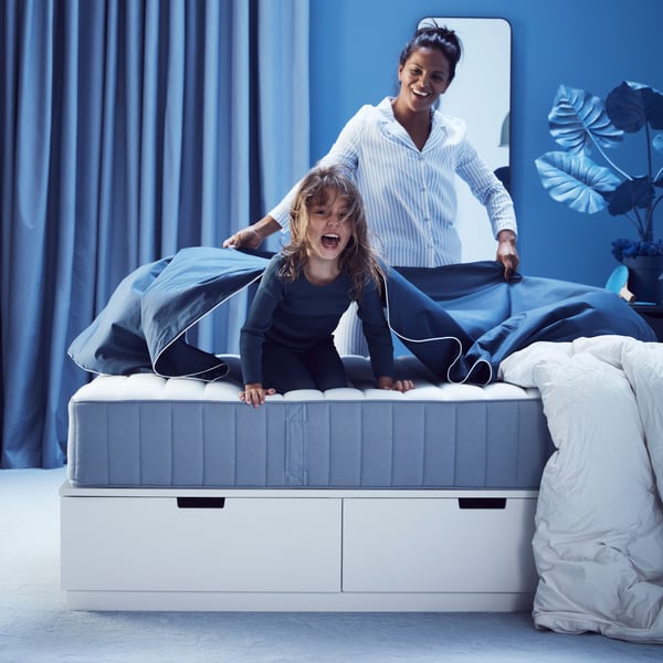 A firm/light blue VALEVÅG pocket sprung mattress in the bedroom
