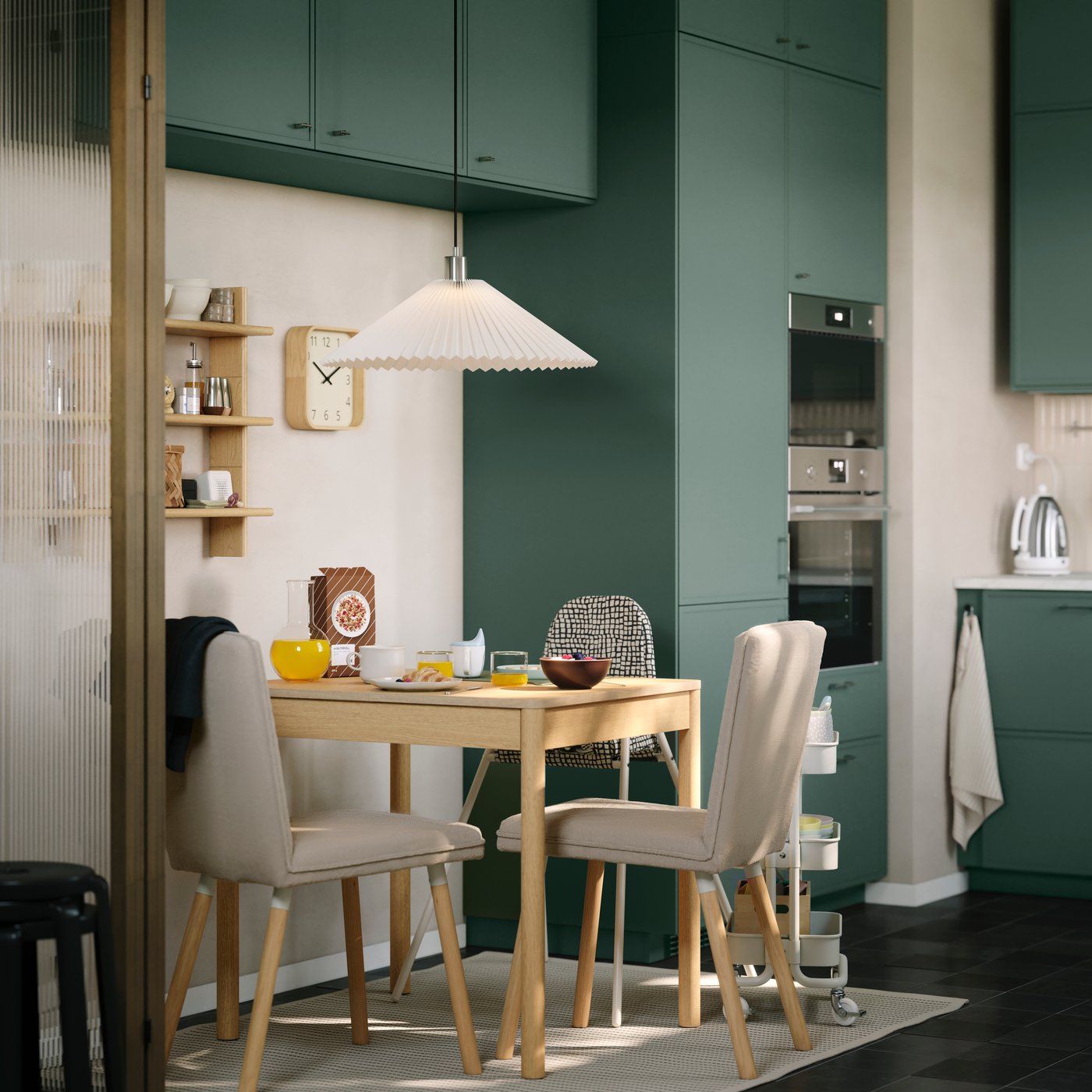 A TONSTAD extendable table in oak veneer with matching upholstered chairs is standing in a small dining area in a kitchen.