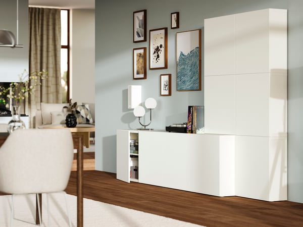 壁一面のホワイト収納とギャラリー風のアートを組み合わせたリビング収納。イケアのホームファニッシングでシンプルなくつろぎ空間を演出。