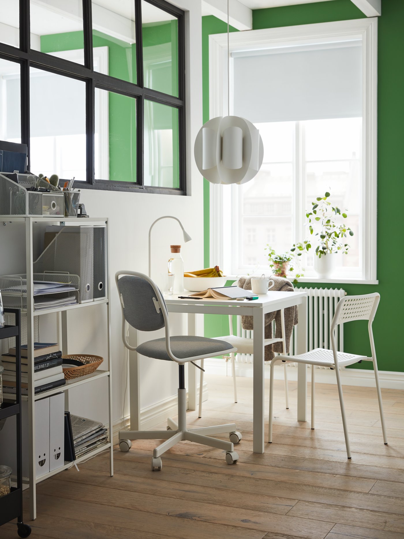 Espacio de trabajo con una silla giratoria, dos sillas, una mesa, una estantería, una lámpara de trabajo LED y una lámpara de techo.