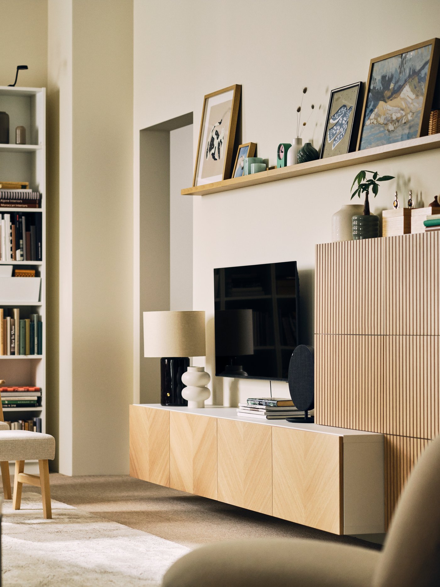 A neat, bright living room with a BESTÅ storage combination with oak-veneer fronts, bookshelves and an EKENÄSET armchair.