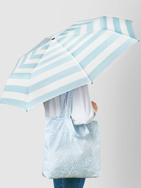 A foldable blue/white KNALLA umbrella