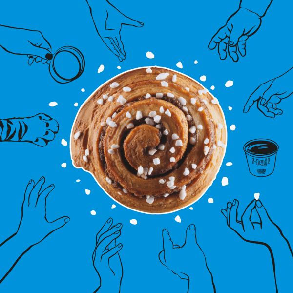 Kanelipulla, jonka päällä raesokeria , on sinistä tautaa vasten.