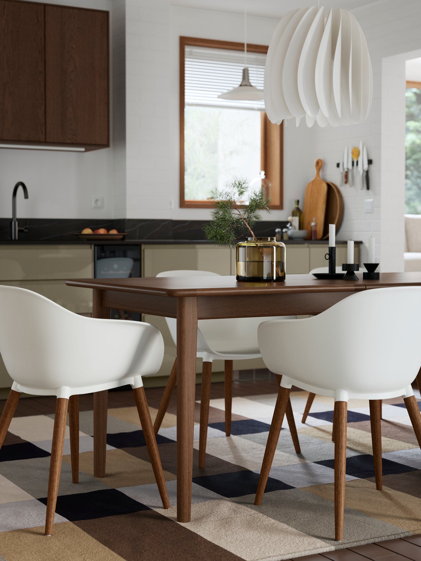 A SKANSNÄS extendable table in brown beech veneer has white GRÖNSTA chairs with armrests and a white SKYMNINGEN pendant lamp.