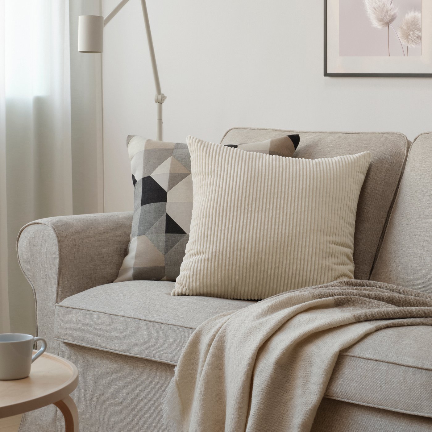 A light beige ÅSVEIG cushion cover in the living room
