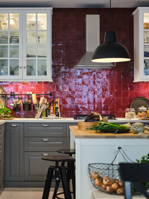 A red-tiled kitchen with white wall cabinets, METOD cabinets with MAXIMERA interiors, a white island with a wooden worktop.