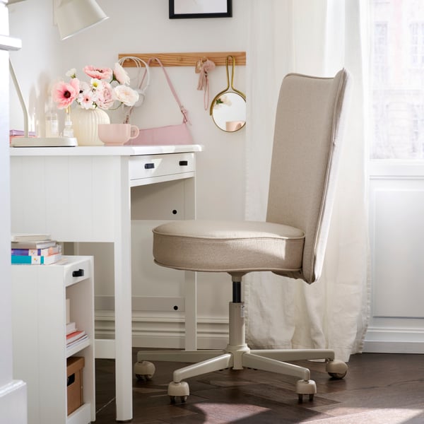 Vit smingsttation med rosa detaljer och beige stol. 