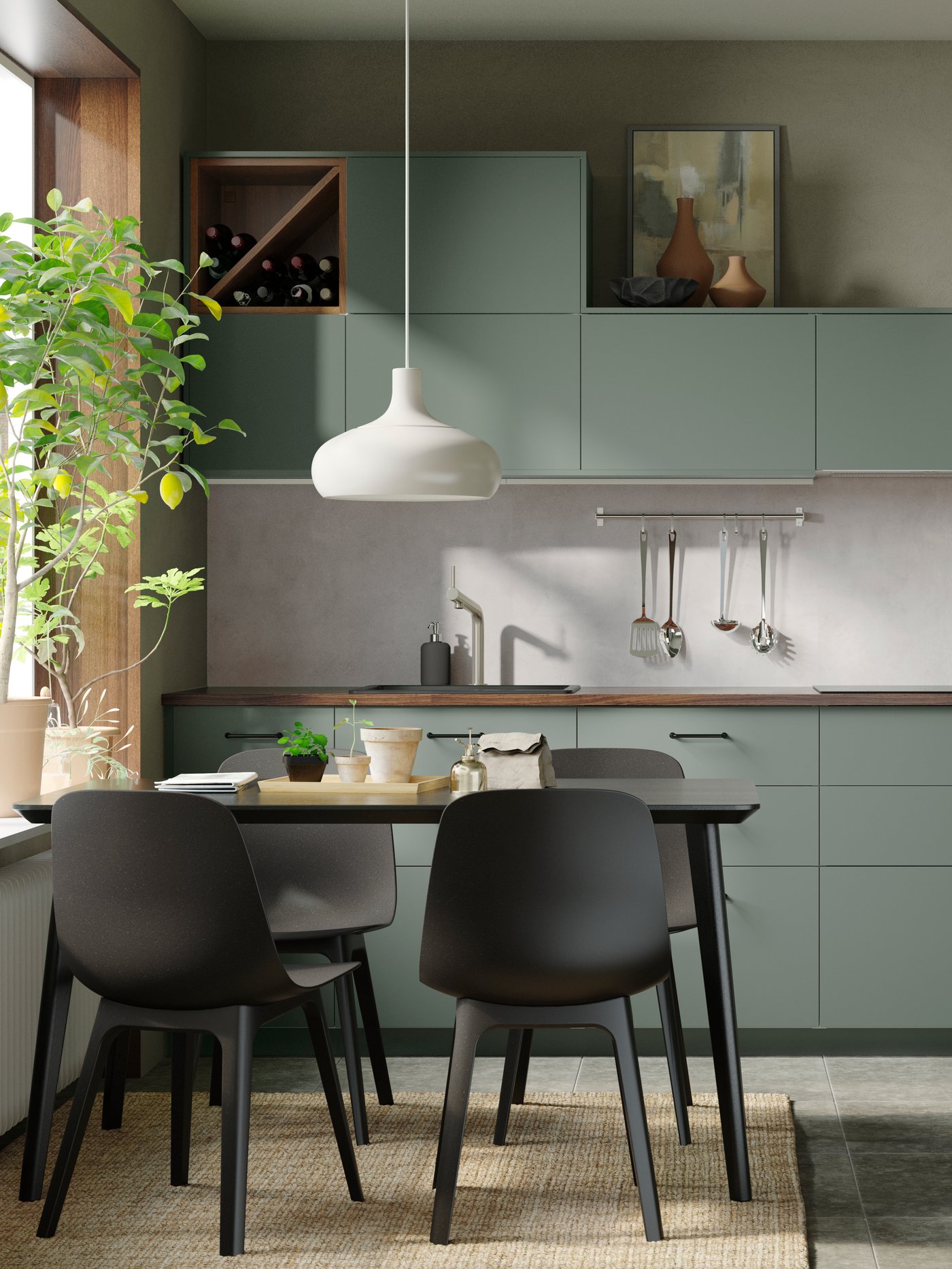 Eine helle, graugrüne BODARP Küche und ein schwarzer Küchentisch mit vier schwarzen Stühlen.