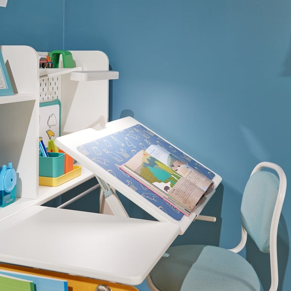A white BERGLÄRKA desk top and shelf in children's room