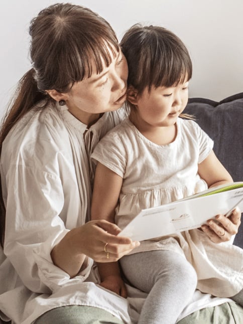 大人が子どもに読み聞かせをしている様子