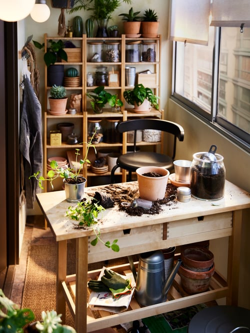 Bamboo RÅGRUND shelving units with plants and storage, behind a birch kitchen trolley with an anthracite YNGVAR bar stool.