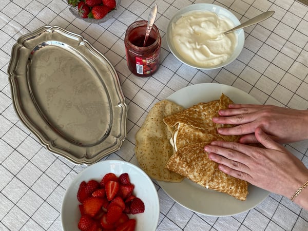 Bild på en person som viker ihop sista lagret av en pannkakstårta.