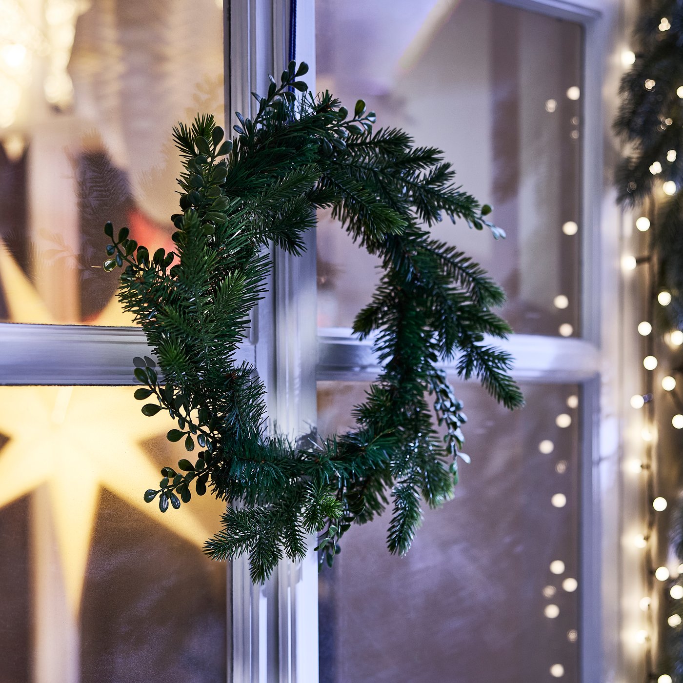An in/outdoor green VINTERFINT artificial wreath outside