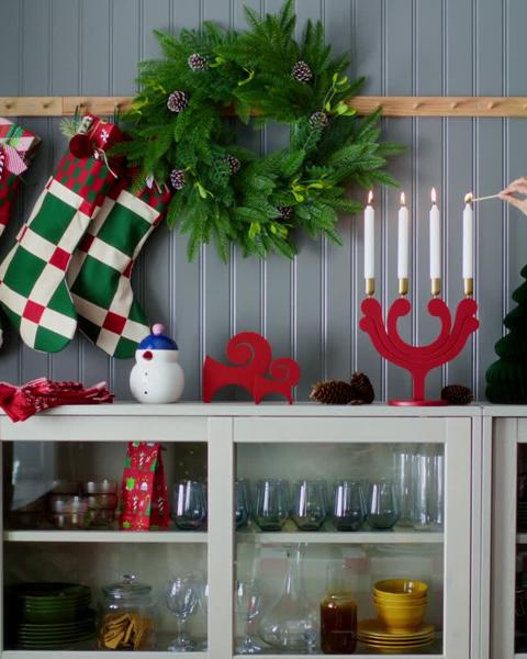 Joulukoristeet olohuoneessa: kranssi, joulusukat, koristeltu kuusi, lahjapaketteja ja juhlapöytä.