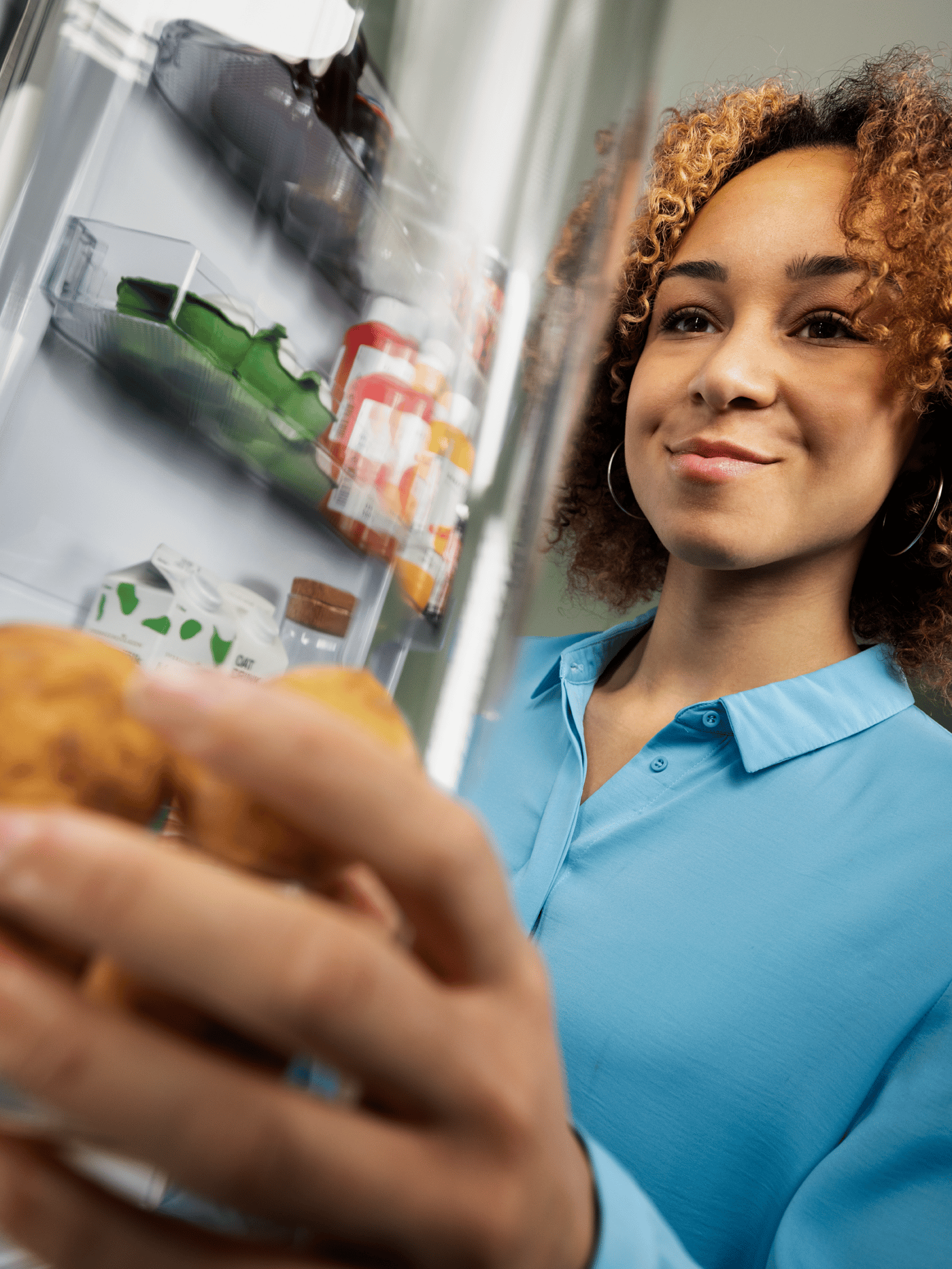 A lady taking out leftover from the refrigerator.