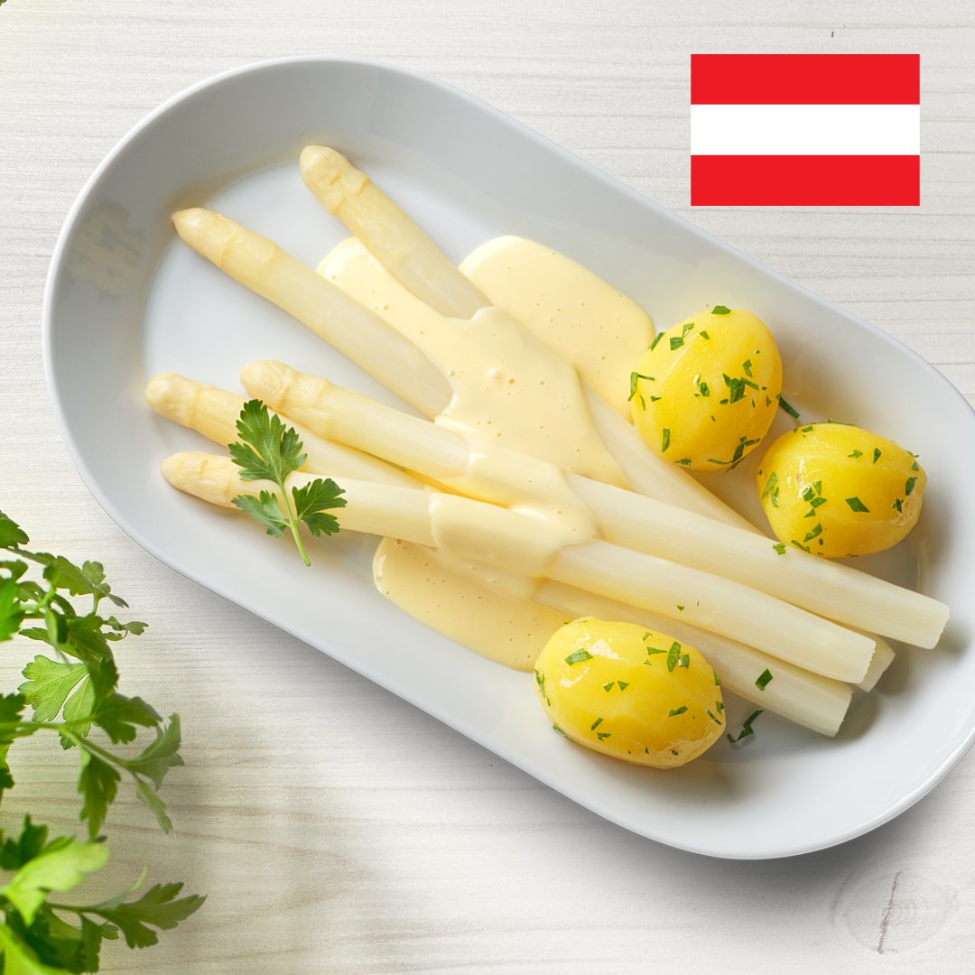 Spargel mit Kartoffeln und Sauce Hollandaise auf einem weißen Teller präsentiert