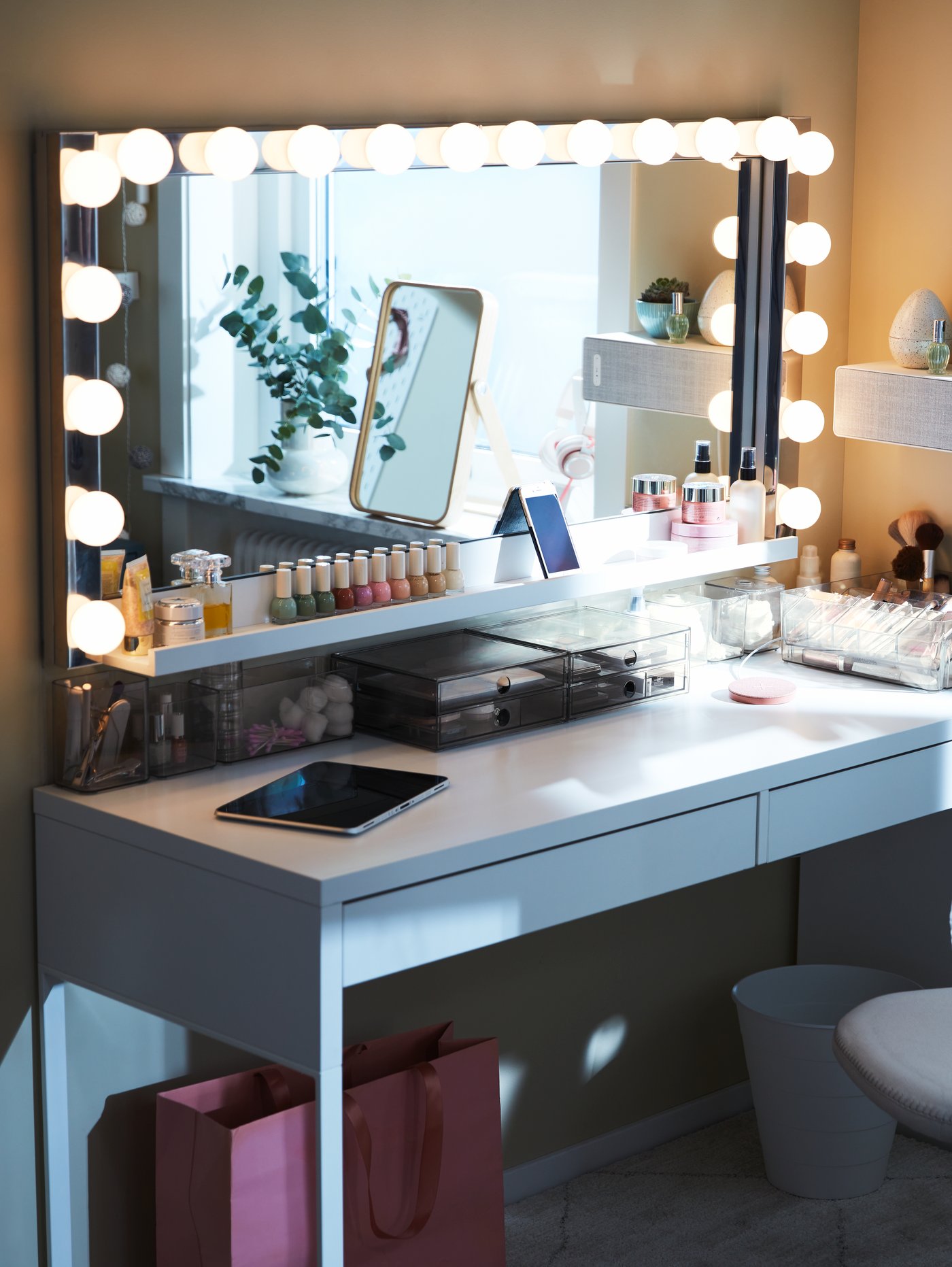 Dormitorio con una lámpara de pared LED gris de acero que rodea un espejo rectangular con un estante para cuadros en la parte inferior.