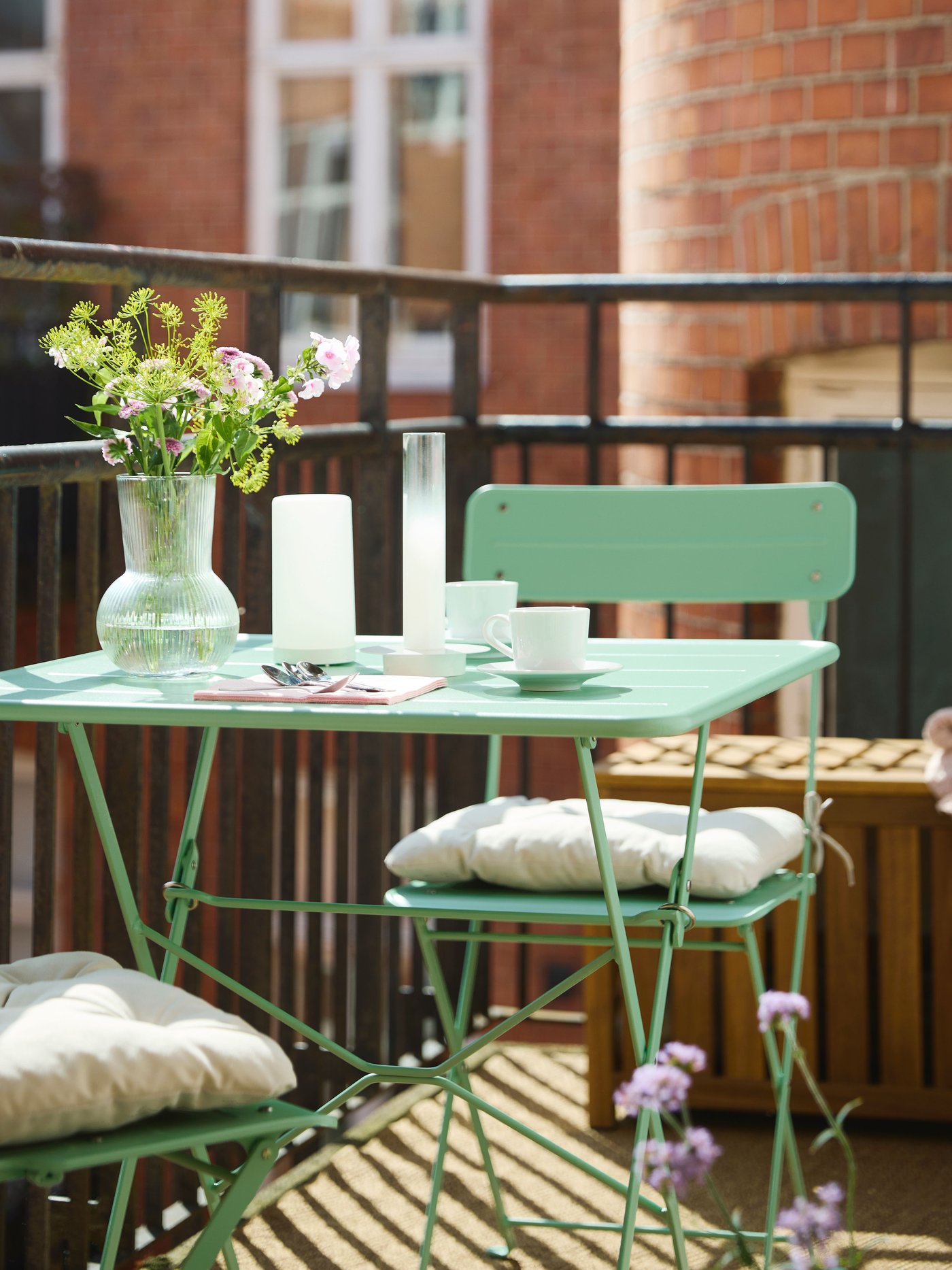 Et klappstol og bord sett på balkong.