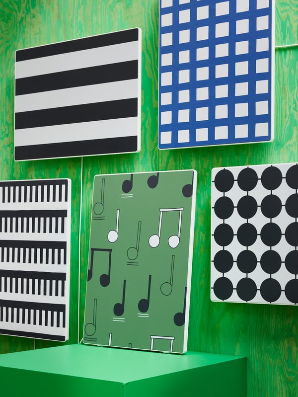 Four speakers mounted on a green wall. One is placed on a pedestal. All with SYMFONISK panel for picture frame speaker.