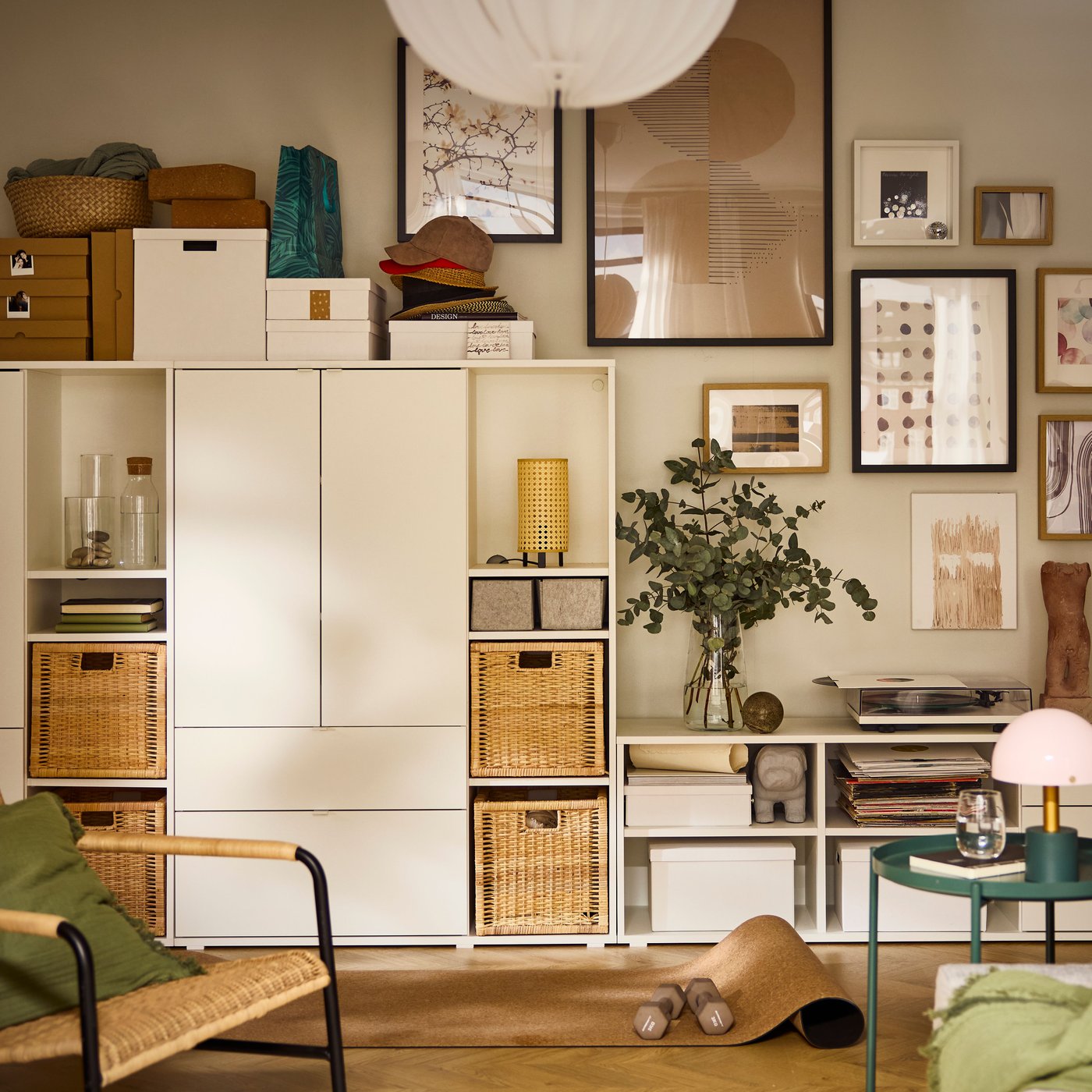A living room wall is half-covered by a white VIHALS storage combination, the other half covered by a cluster of framed art.