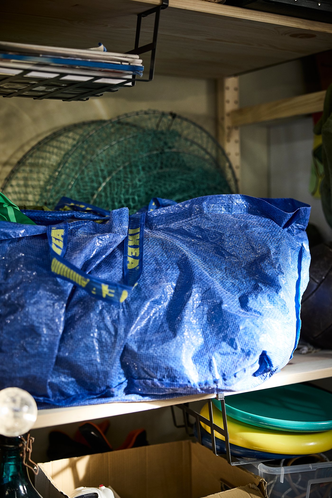 An anthracite PÅLYCKE clip-on basket in the garage